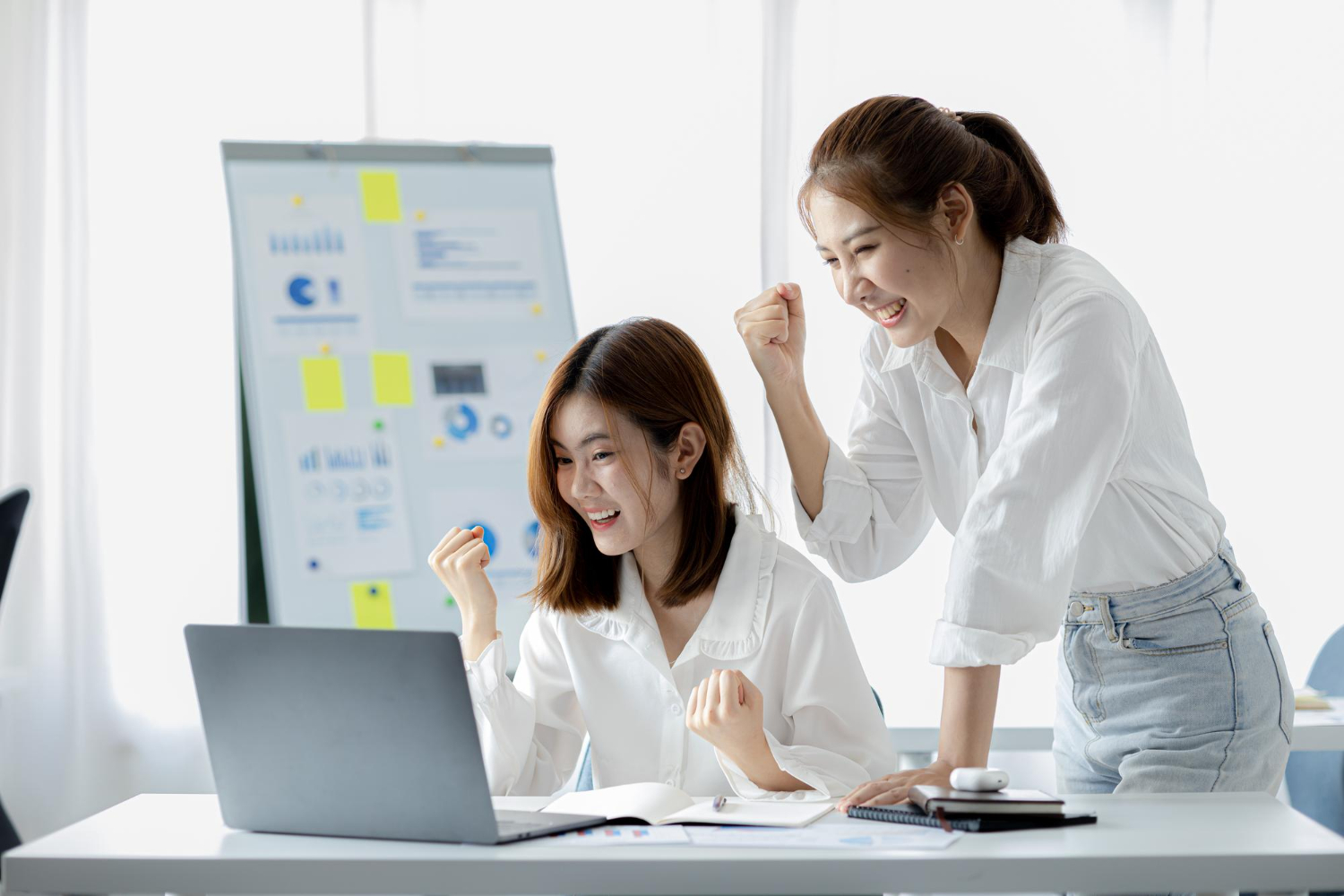 two-women-showing-joy-looking-data-their-laptop-two-business-women-looking-monthly-summary-sales-that-exceeded-sales-targets-achieved-profitable-growth-sales-management-concept